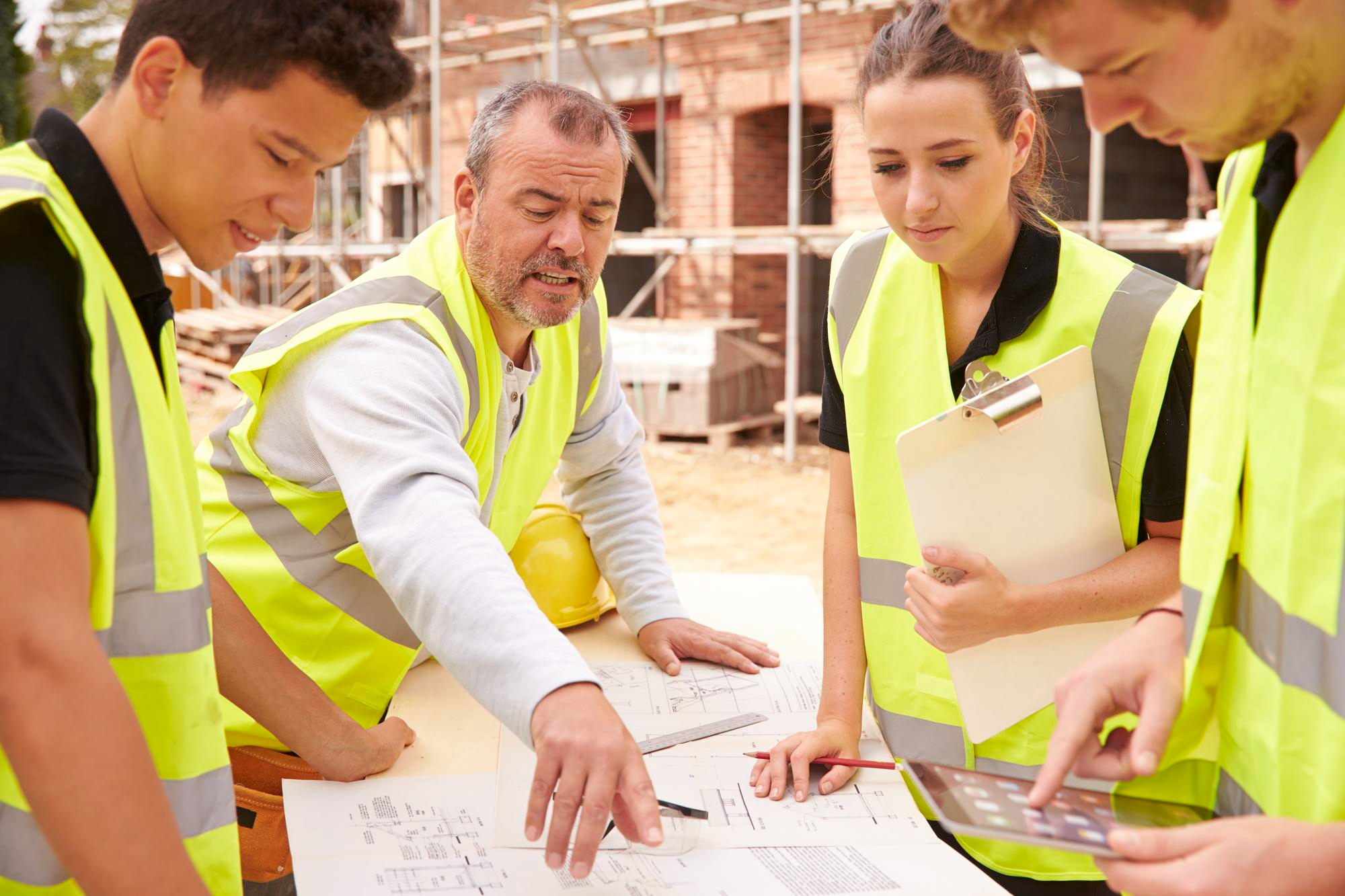Imagen de operarios en una obra de construcción realizando una reunión